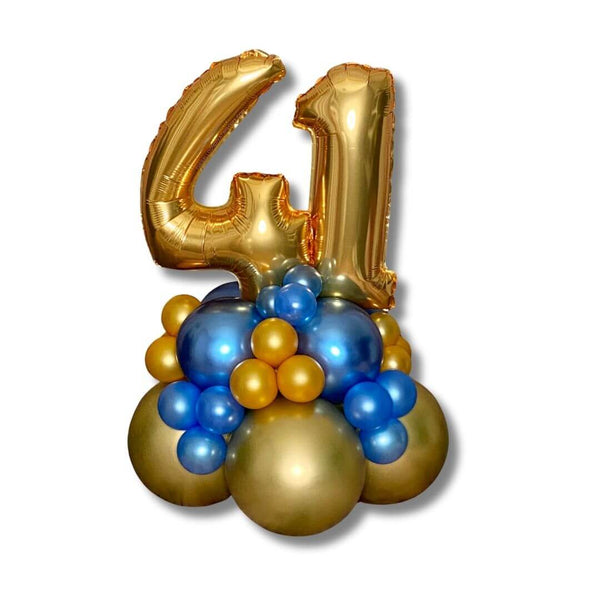 Blue & Gold Bubbly Number Balloon Centerpiece. Featuring a 14 inch gold number foil balloon and a dazzling mix of blue and gold balloon clusters.