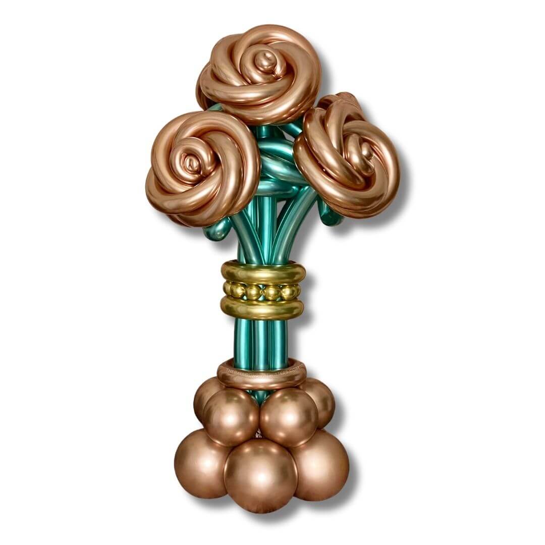 Rose Gold Roses Flower Balloon Bouquet feature 4 large chrome rose gold roses with chrome green leaves and stems sitting on a chrome rose gold balloon base with chrome gold embellishments.
