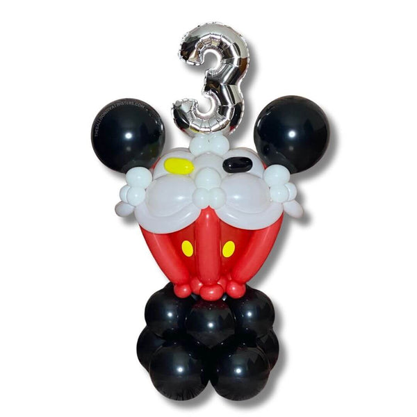 Happy Mouse Colossal Cupcake Birthday Balloon Sculpture is a 2 feet large cupcake balloon sculpture with red cake, white icing, red, yellow, and black sprinkles. The top features a 14 inch silver number foil balloon and black mouse ears.