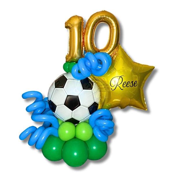 Sports Soccer Birthday Balloon Marquee features a 17 inch soccer ball foil balloon, shiny gold number balloon to showcase their age, a personalized gold star with their name, lively blue balloon curls on a green balloon base.