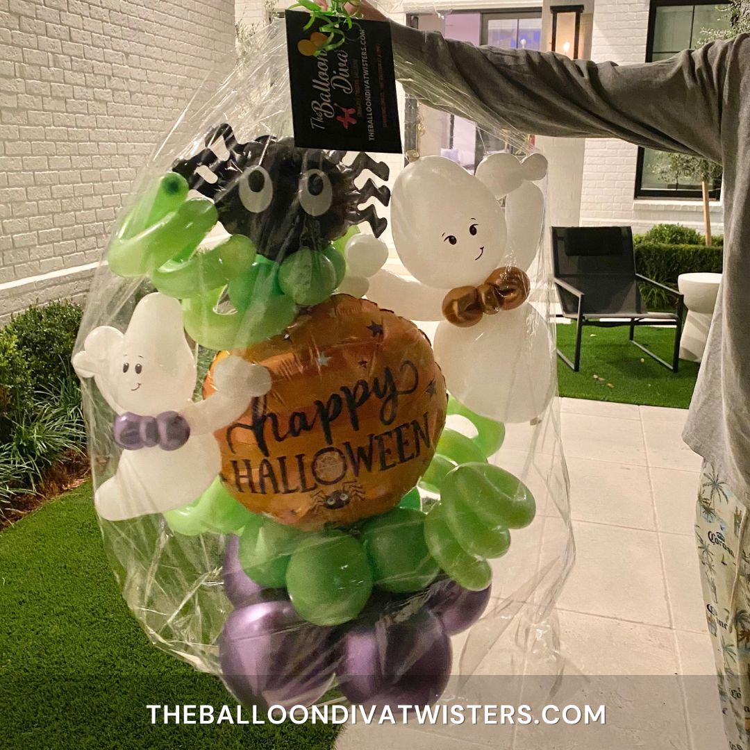 Ghostly Greetings Halloween Balloon Marquee features a Happy Halloween foil balloon, cute spider foil balloon, and two friendly ghosts sculptures with chrome purple and lime green balloons.